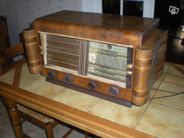 Un vieux poste de radio qui trône sur la table d'une cuisine.