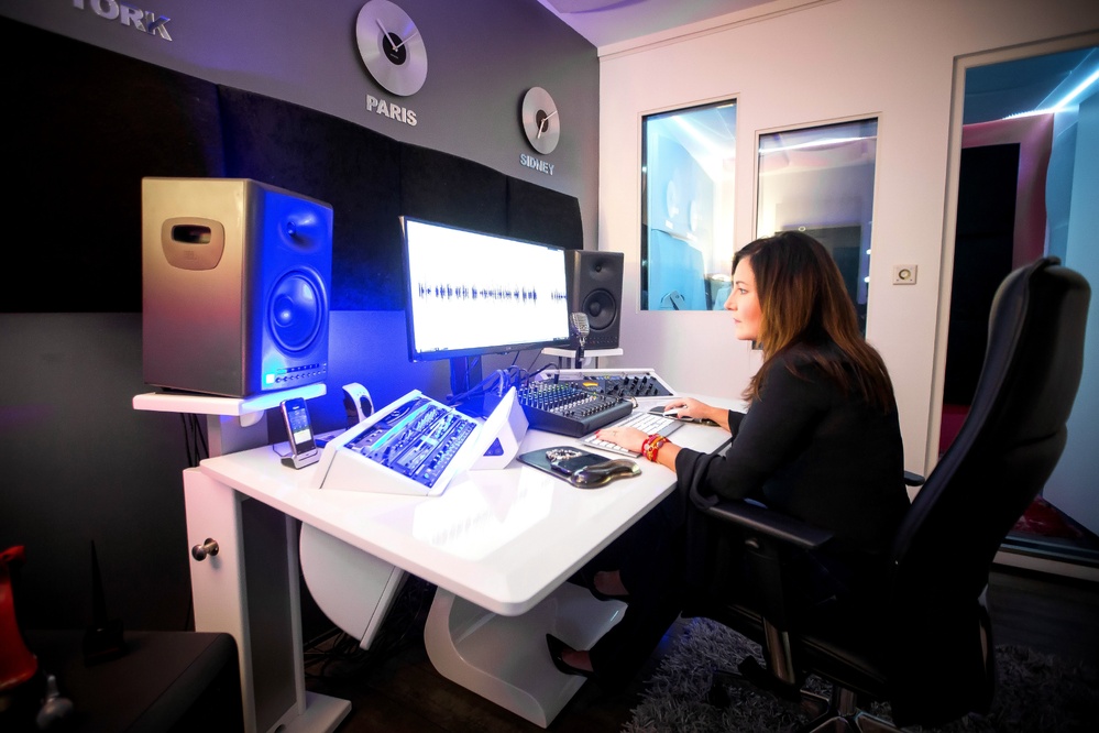 Derrière son micro, Estelle Hubert travaille chaque phrase avec minutie. Dans ce studio qu’elle a imaginé comme un atelier, chaque prise est façonnée à l’écoute du message. C’est ici, seule face à la console, qu’elle donne vie aux mots des autres.