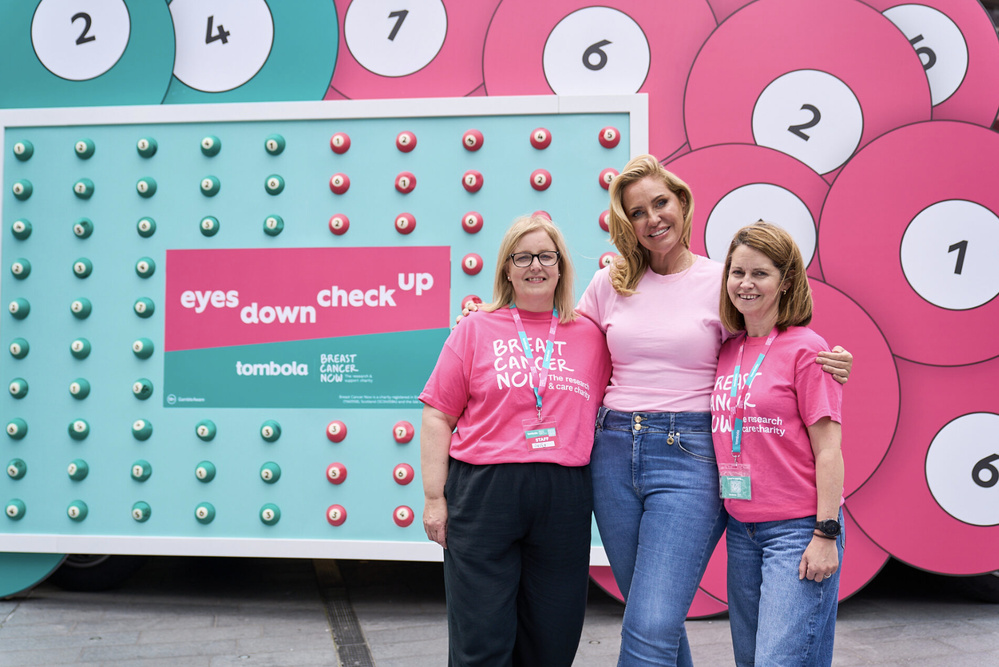 L’animatrice britannique Katherine Ryan, entourée de bénévoles de "Breast Cancer Now", lors du lancement de la campagne audio nationale menée par Bauer Media et Tombola pour le "Breast Cancer Awareness Month". Une opération diffusée sur Hits Radio et Magic Radio pour encourager le dépistage précoce autour du message "Who are you checking for ?".