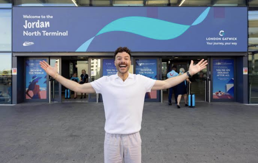 Jordan North devant le terminal nord de l’aéroport de Londres Gatwick, rebaptisé pour une journée "Jordan North Terminal" dans le cadre d’une opération menée avec la matinale "Capital Breakfast" et TUI. Source : TUI / Capital Breakfast / London Gatwick.