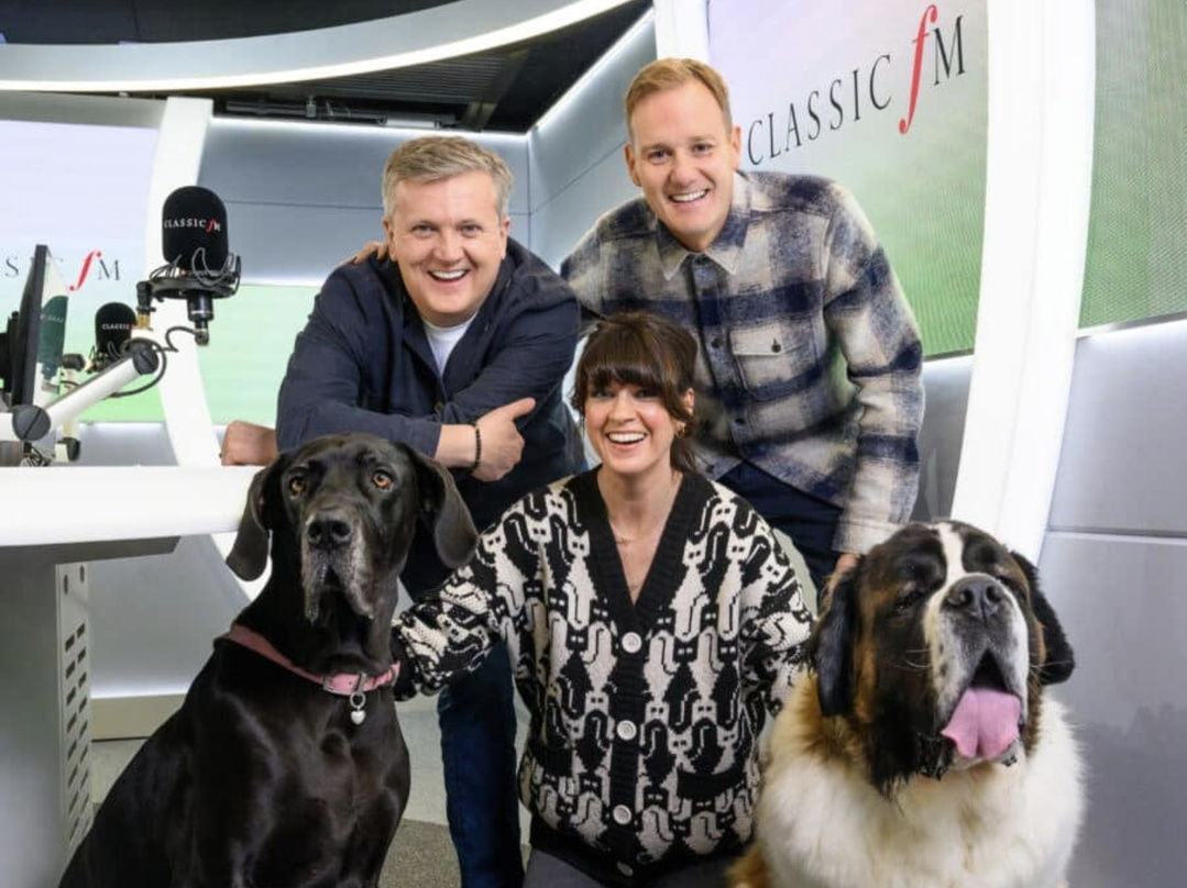 Dan Walker, Dawn O'Porter et Aled Jones, les trois animateurs de "Pet Classics", réunis dans les studios de Classic FM avec deux chiens. Du 5 au 7 novembre 2026, ils présenteront chacun une soirée de cinq heures de musique classique destinée à apaiser les animaux pendant les feux d'artifice. Source : Classic FM / Global.