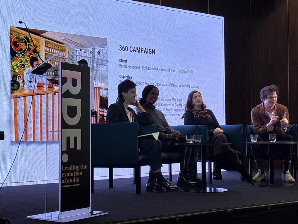 Le panel discute des campagnes 360. En fond, slide "360 Campaign" détaillant un partenariat avec Baron Philippe de Rothschild pour Mouton Cadet. Arthur Soria applaudit.